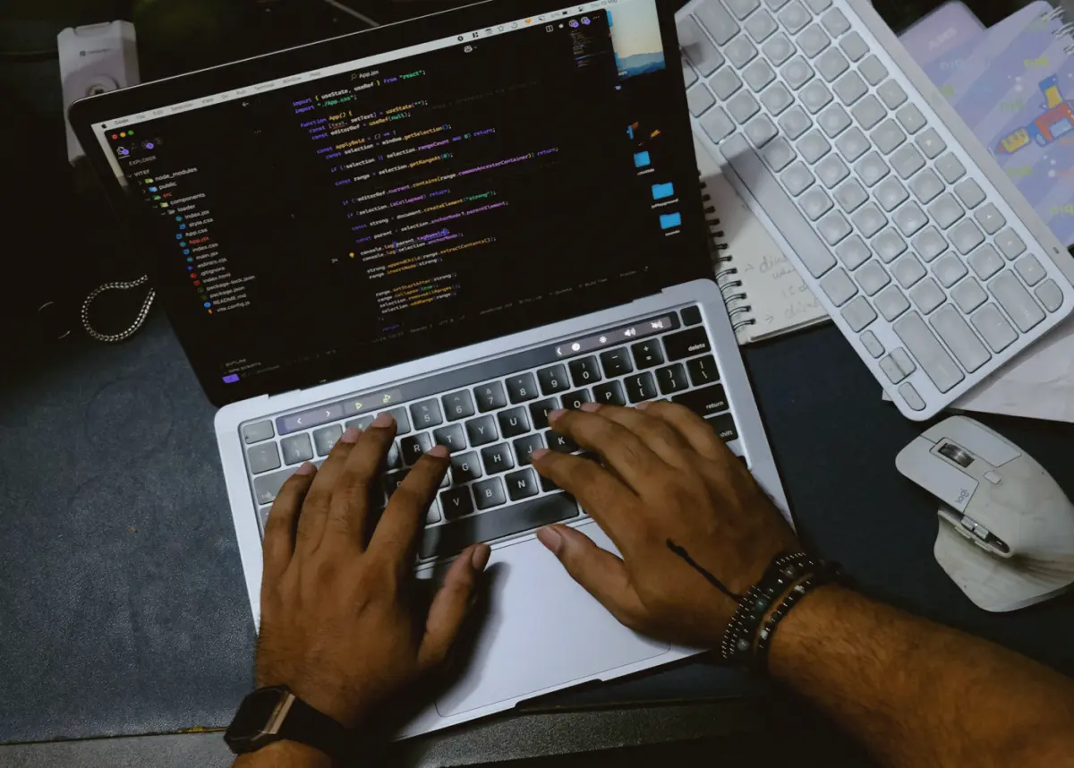 Handen op een laptop met code op het scherm